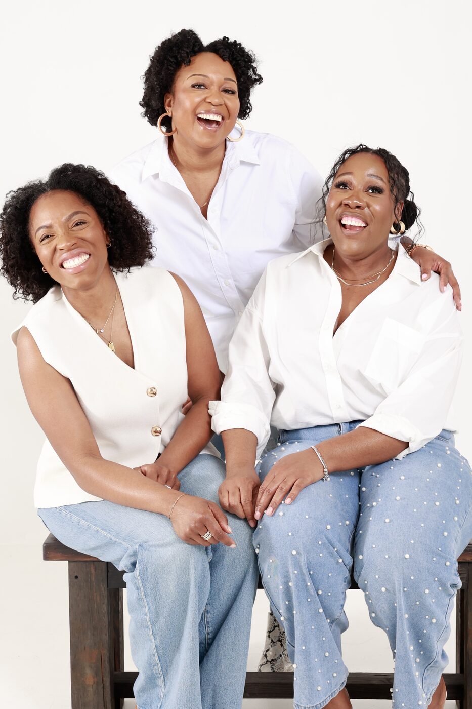 Women of BLOOM seated together on a bench, laughing